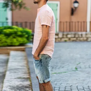 Profil latéral d'une chemise rose à manches courtes pour homme avec col officier.