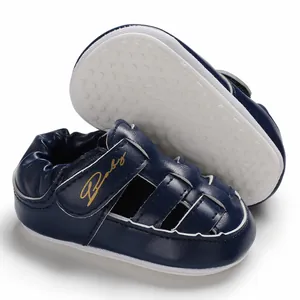 Detail view of navy blue infant walking sandals with non-slip white rubber soles.