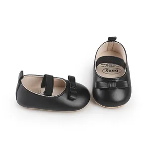 Détail de chaussures de marche noires pour bébé fille avec nœud et sangle élastique