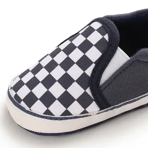 Detailed view of navy blue soft-sole baby shoes featuring a classic black and white checkerboard.