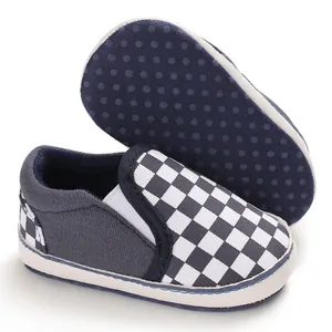 Close-up of baby walking shoe with checkered pattern and dotted anti-slip sole.