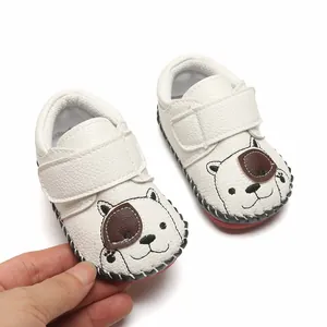 Vue détaillée de chaussures de marche pour bébé blanches avec broderie d'ours mignonne