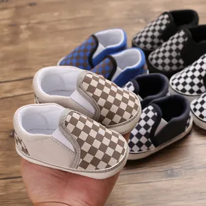 Selection of checkerboard slip-on soft sole baby walker shoes displayed in hand