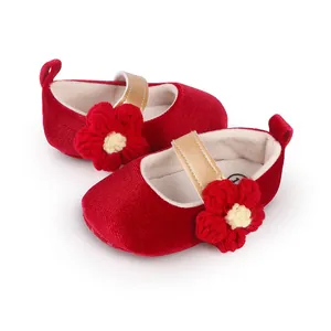 Close-up of red velvet baby girl princess shoes with soft sole and crocheted flower