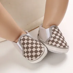 Detail of soft-soled brown checkered slip-on infant walker shoes for 0-1 year olds.