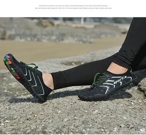 Primo piano di scarpe da scoglio nere con sistema di lacci rapidi sulla spiaggia.