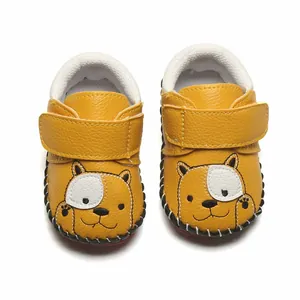 Vue détaillée de chaussures de marche bébé jaunes avec un motif chien et velcro