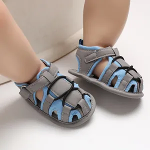 Primo piano di comodi sandali estivi per bambini con suola morbida blu e grigio sui piedi