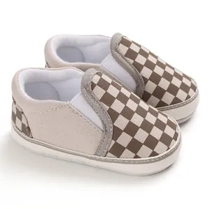Macro detail showing the texture of brown and white checkered baby slip-on walker shoes.