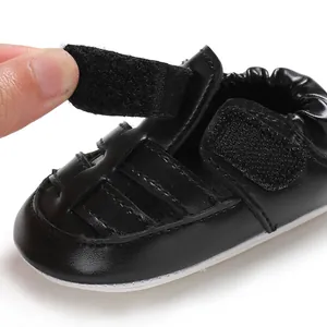 Detail showing the adjustable hook and loop strap on these black baby walker sandals