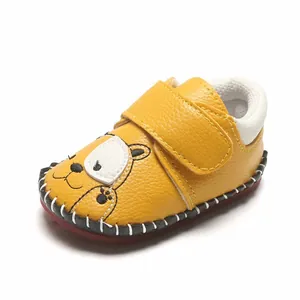 Détail de chaussures de bébé jaunes avec semelle en caoutchouc souple et motif ours