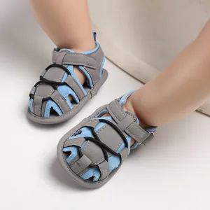 Vista dettagliata dei sandali da passeggio per bambini in blu e grigio indossati da un neonato.