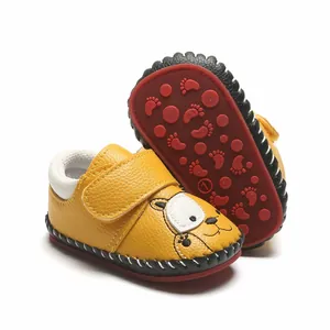 Vue détaillée de chaussures bébé jaunes avec tête d'ours et semelle en caoutchouc rouge