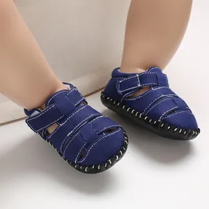 Primo piano di sandali per neonati in tela blu navy con cuciture bianche e velcro