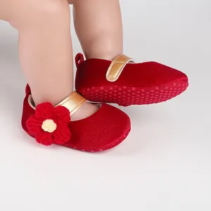 Close-up of red velvet baby walking shoes with handcrafted flower and anti-slip sole