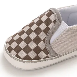 Detailed macro shot of brown and beige checkered baby walking shoes with soft white sole