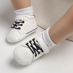 Close-up detail of white high-top leather baby walking shoes with navy laces
