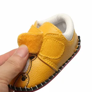 Détail de la chaussure de marche jaune pour bébé avec semelle souple et bande velcro