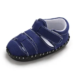 Vista laterale di sandali primi passi per neonati in tela blu navy con cinturino in velcro