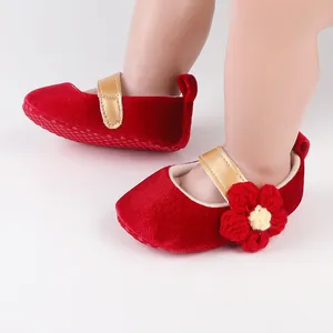 Detail of red velvet baby shoes with gold strap and crochet flower for 0-1 year old infants