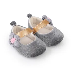 Detailed view of grey velvet baby girl princess shoes with gold strap and flower