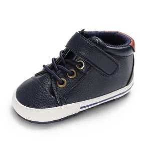 Close-up detail of navy blue leather high-top baby walking shoe with soft white sole
