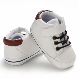 Detailed view of white high-top leather baby shoes with soft soles for infants.