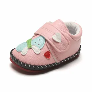 Gros plan sur chaussures de marche roses pour bébé en cuir avec décorations cœur