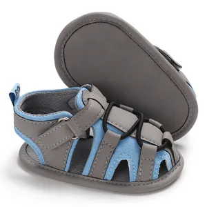 Dettaglio dei sandali estivi per neonati con suola morbida in mesh blu e grigio