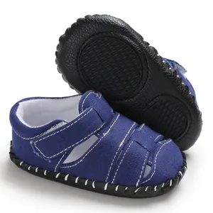 Dettaglio dei sandali blu per neonati con suola in gomma antiscivolo e velcro
