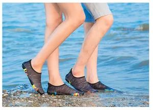 Gros plan de chaussures d'eau légères à séchage rapide portées sur une plage rocheuse