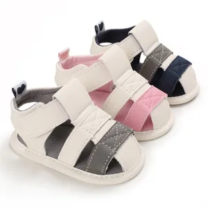 Detailed view of three pairs of soft-sole baby sandals in grey, pink, and navy blue