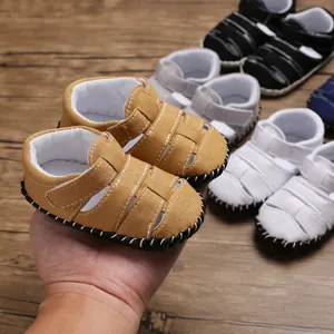 Primo piano di sandali per neonati in tela con suola in gomma antiscivolo e velcro