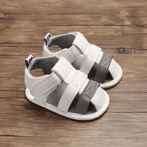 Detailed view of white and grey baby summer sandals with soft soles and velcro straps.