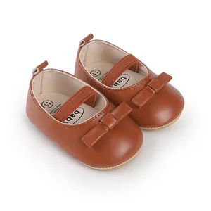 Detail von braunen Baby-Lauflernschuhen aus Kunstleder mit Schleife und elastischem Band