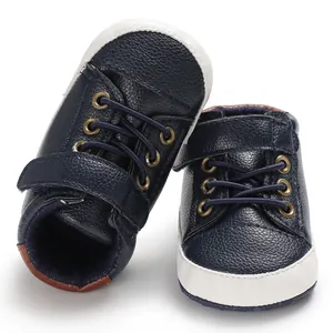 Detailed view of navy blue baby walking shoes with white soft soles and velcro strap.