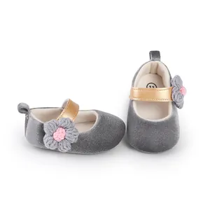 Detailed macro view of grey velvet baby girl walking shoes with a decorative crochet flower detail