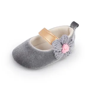 Macro detail shot of grey velvet baby walking shoe featuring a pink crochet flower