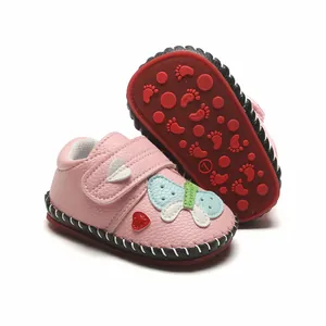 Vue détaillée de chaussures roses pour bébé avec papillon et semelle en caoutchouc.