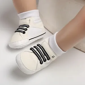 Detailansicht weißer High-Top-Lauflernschuhe mit weicher Sohle und schwarzen Schnürsenkeln