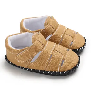 Dettaglio di sandali per neonati in tela kaki con suola in gomma flessibile per bimbi