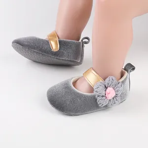 Close-up of grey velvet baby walking shoes featuring a delicate crochet flower detail