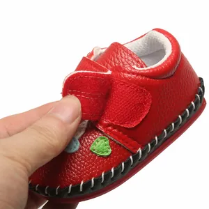 Détail d'une chaussure de marche rouge pour bébé avec texture cuir