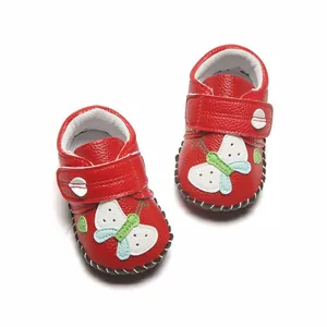 Chaussures de marche souples rouges pour bébé avec papillon blanc et velcro.