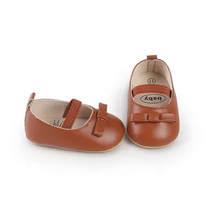 Gros plan sur des chaussures de marche pour bébé marron élégantes avec un joli nœud décoratif