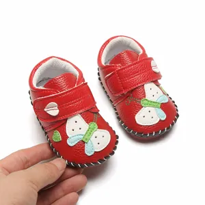 Gros plan détaillé de chaussures de marche souples rouges pour bébé avec applique papillon