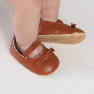 Nahaufnahme von braunen Baby-Lauflernschuhen mit Schleife und weicher Gummisohle