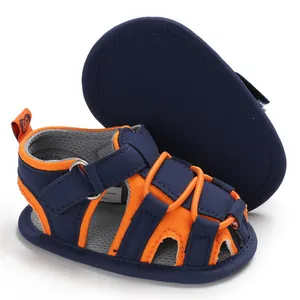 Dettaglio di un sandalo da primi passi per bambini blu e arancione con suola morbida.