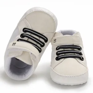 Detailansicht weißer Lauflernschuhe für Babys mit schwarzen Schnürsenkeln und Klettverschluss