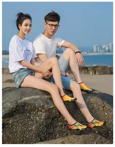 Vue détaillée de chaussures d'eau à motifs colorés portées par un couple à la plage